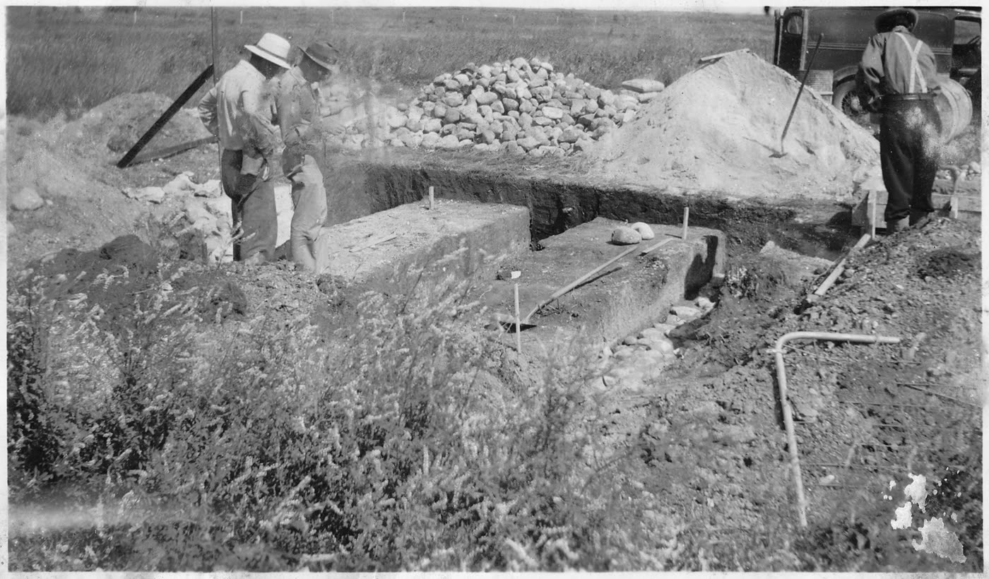 Civilian Conservation Corps crew building a cattle guard in the 1930s — excavated vault and poured concrete footings visible